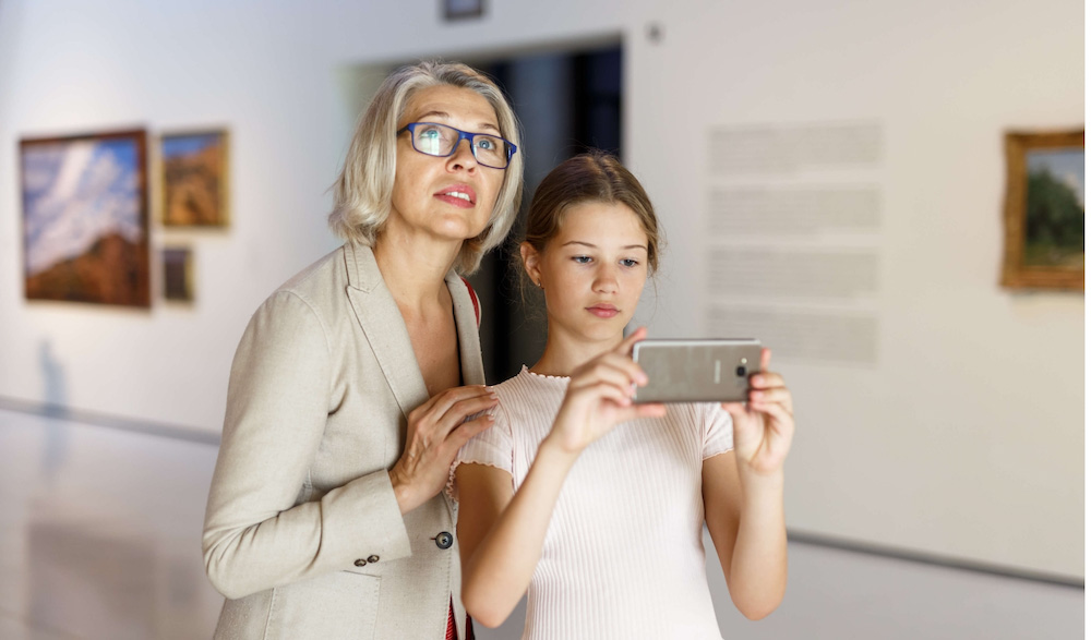 Mum and daughter using mobile in museum