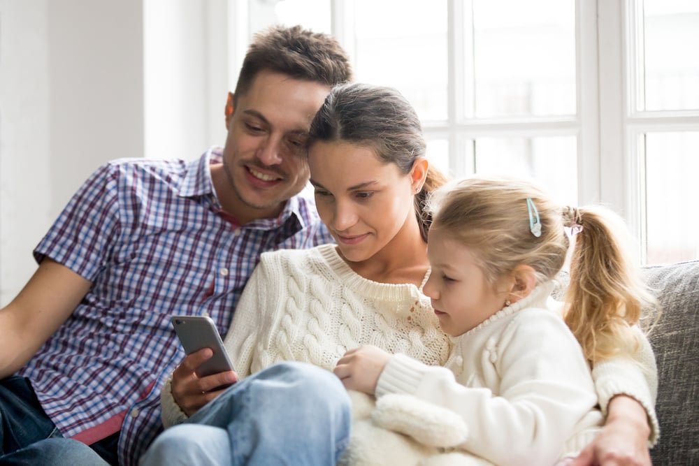 Family back at home looking at zoo app