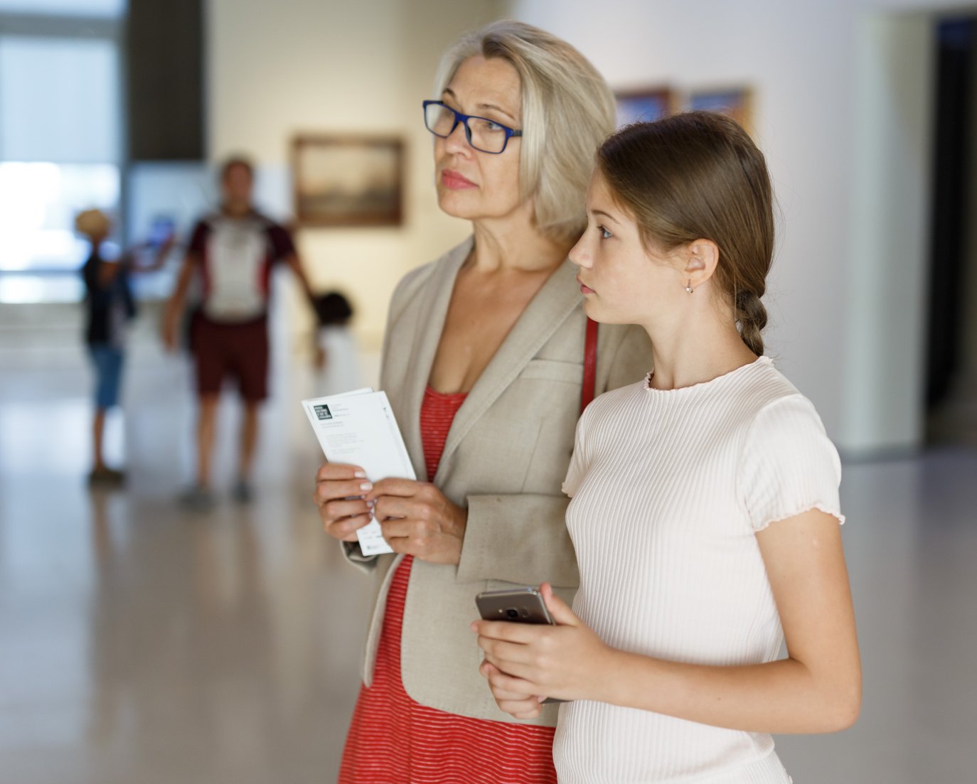 Mum and daughter using mobile phone in museum