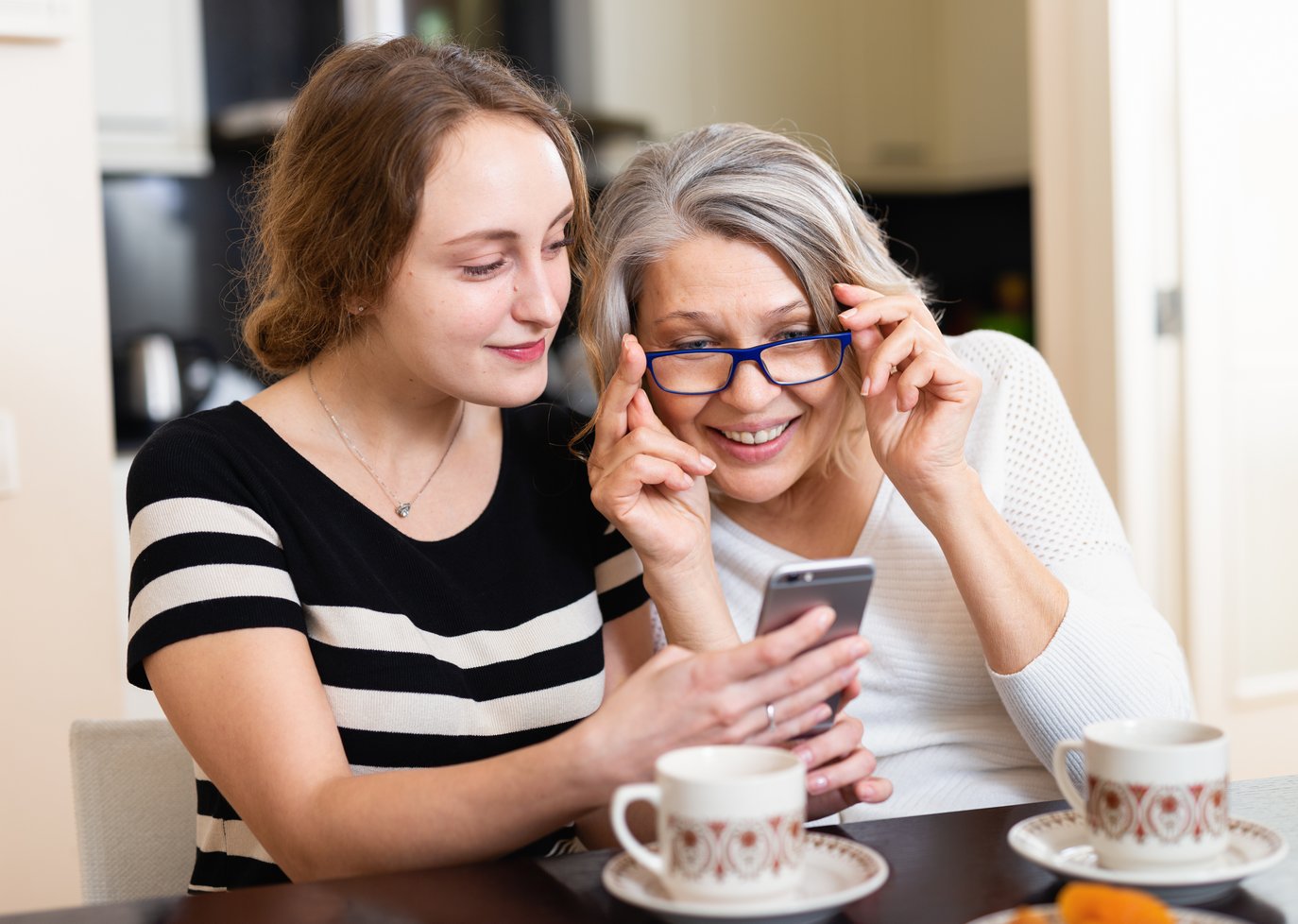 Mum and daughter using mobile app at home