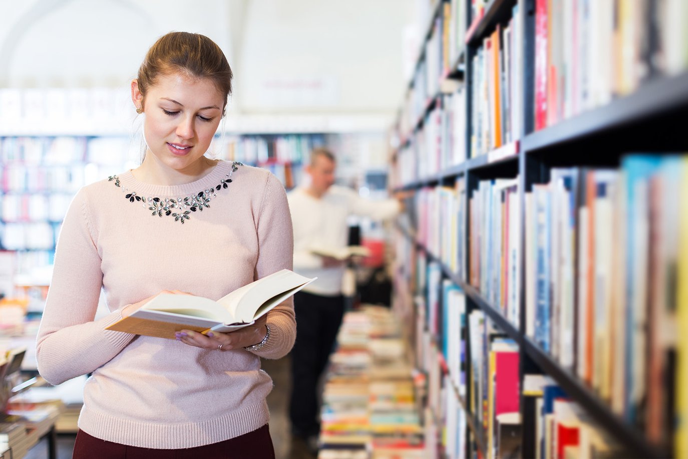 Girl in library looking at history book